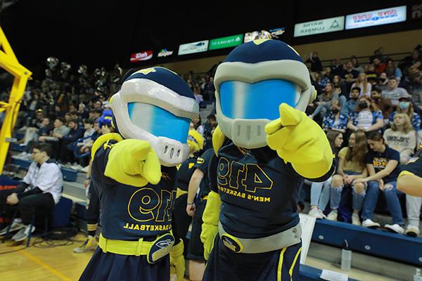 Rocky and Rocksy in a basketball arena, pointing at the camera